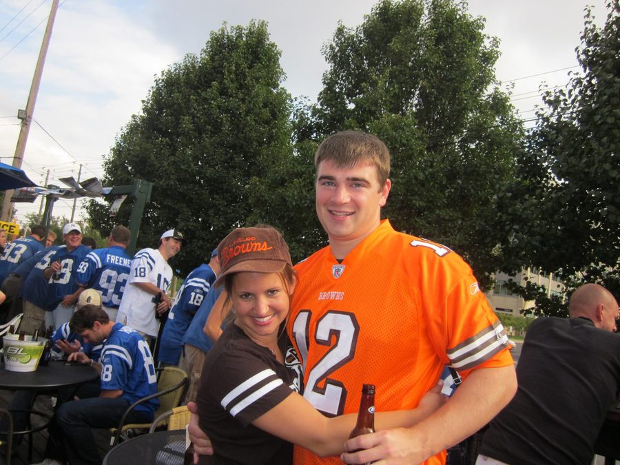 A couple in Browns and Colts jerseys at a football game tailgate.