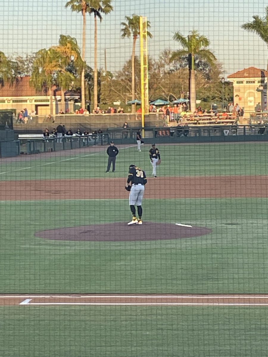 A baseball field at Ed Smith Stadium with a pitcher on the mound during spring training.
