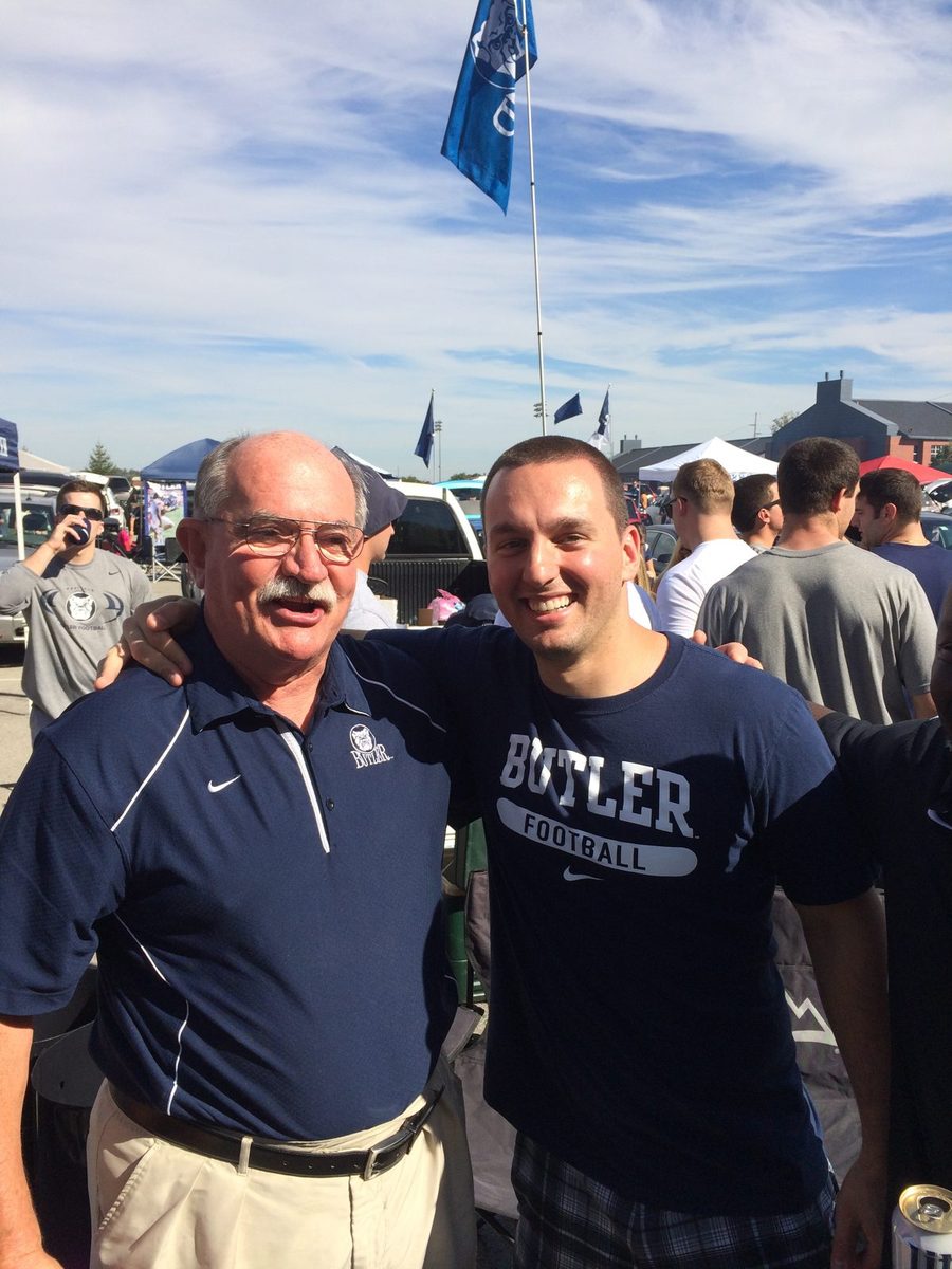 Three men posing at a Butler football tailgate, one in a Butler Football shirt.