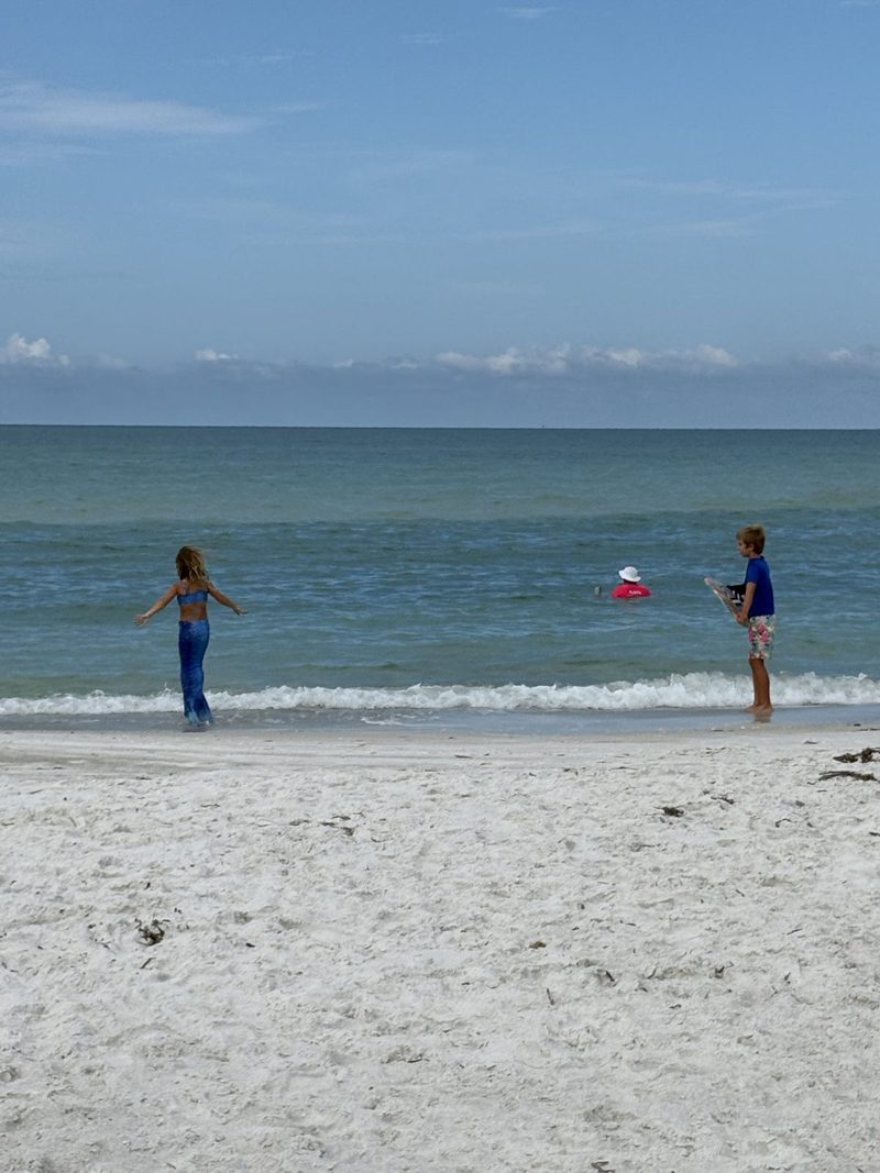 Two children playing at the edge of the Gulf on Longboat Key.